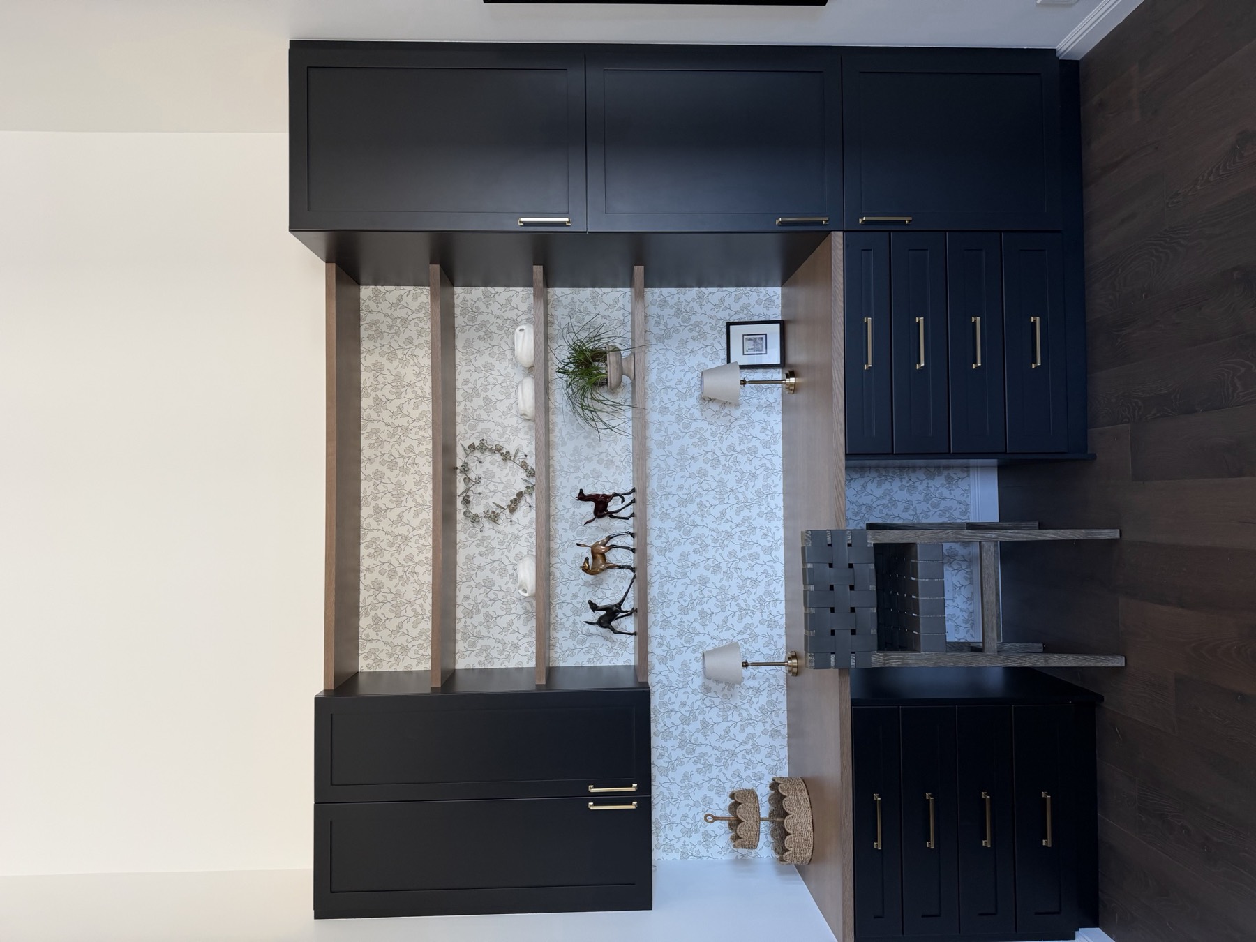 A built-in desk nook set between full-height cabinets, with drawer storage below and open shelving above.